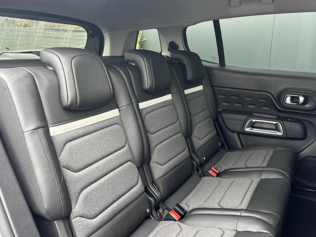 Vue latérale des trois sièges arrière indépendants en cuir et tissu gris du Citroën C5 Aircross 2025, avec appuis-tête réglables.