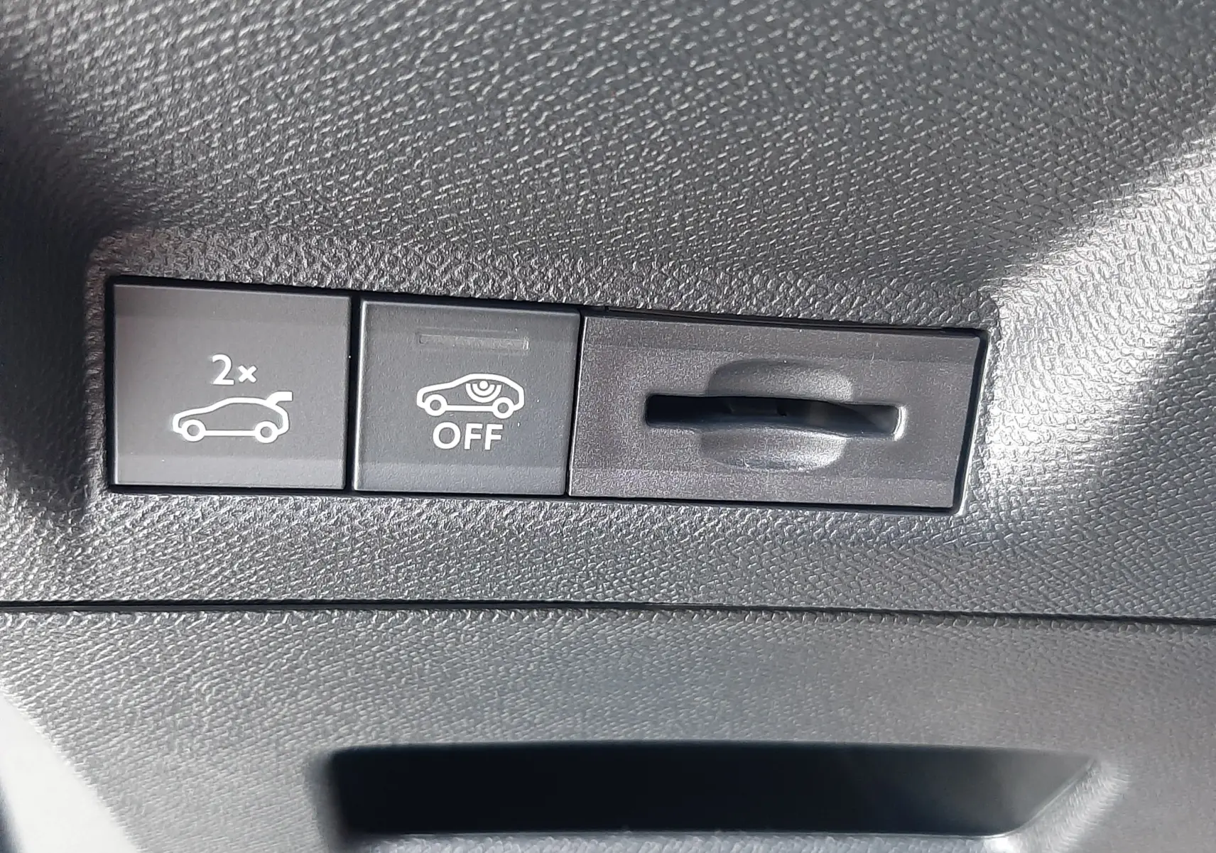 Détail intérieur du tableau de bord du Peugeot 3008 1.2 Hybrid, montrant les boutons de commande du hayon et de l'alerte de sécurité.