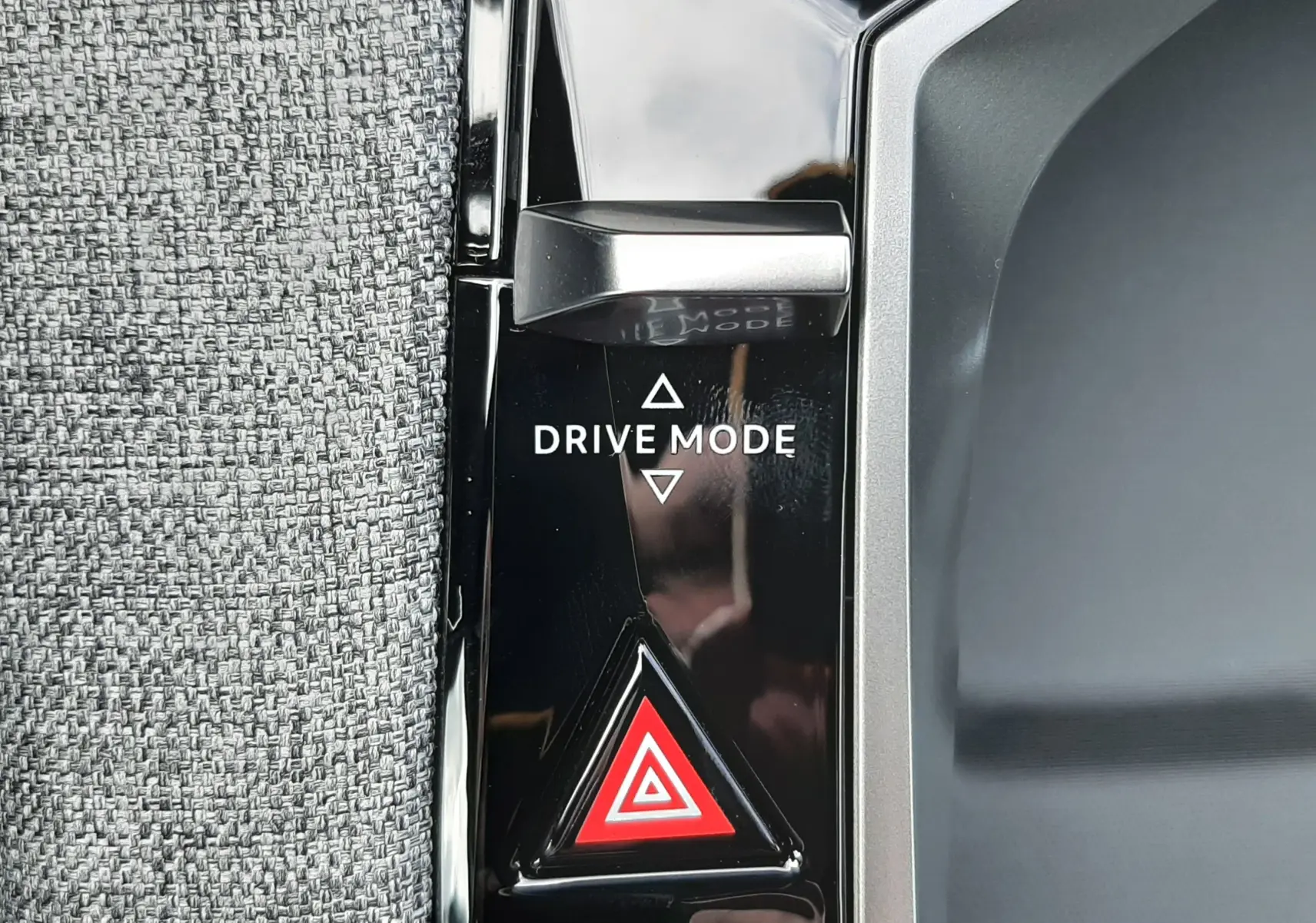 Détail du bouton Drive Mode et du signal de détresse sur la console noire brillante d’un Peugeot 3008 hybride.