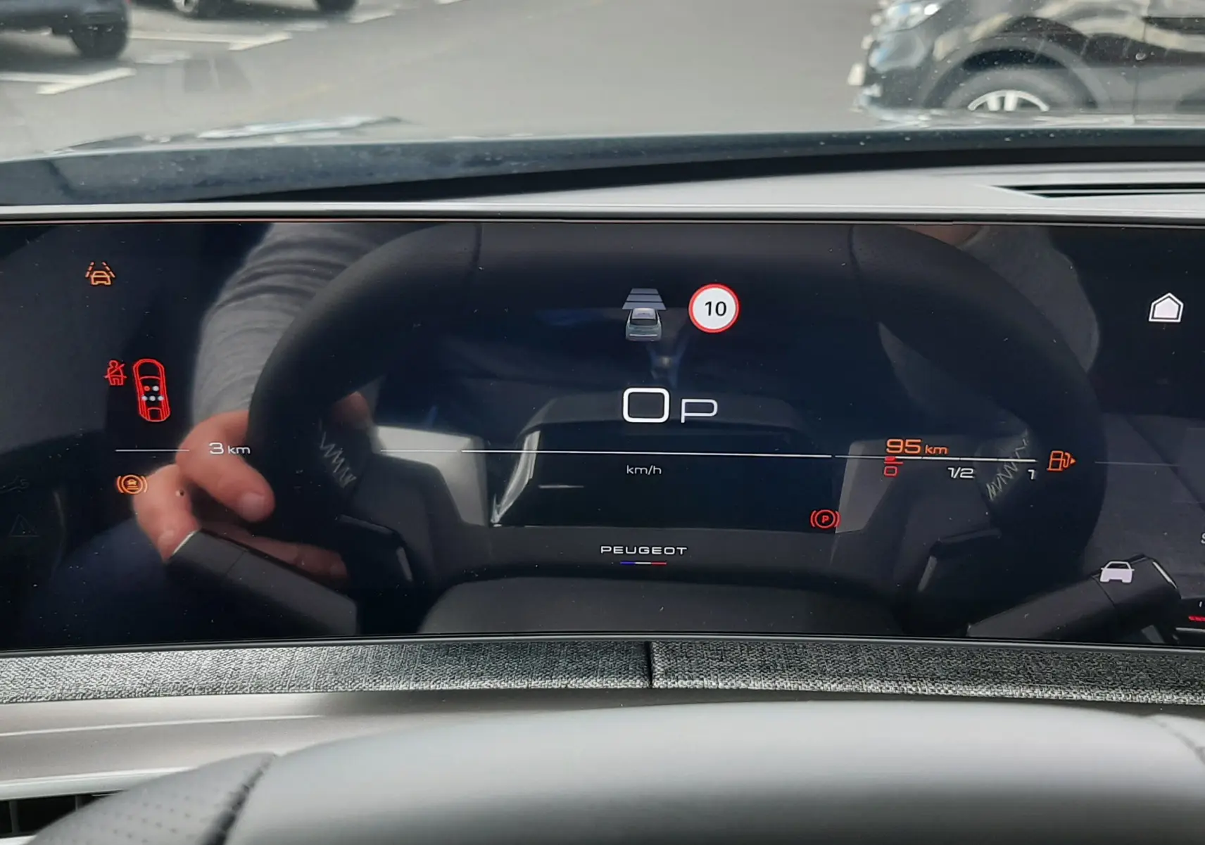 Tableau de bord numérique du Peugeot 3008 gris titane, affichage vitesse et aides à la conduite en vue frontale.