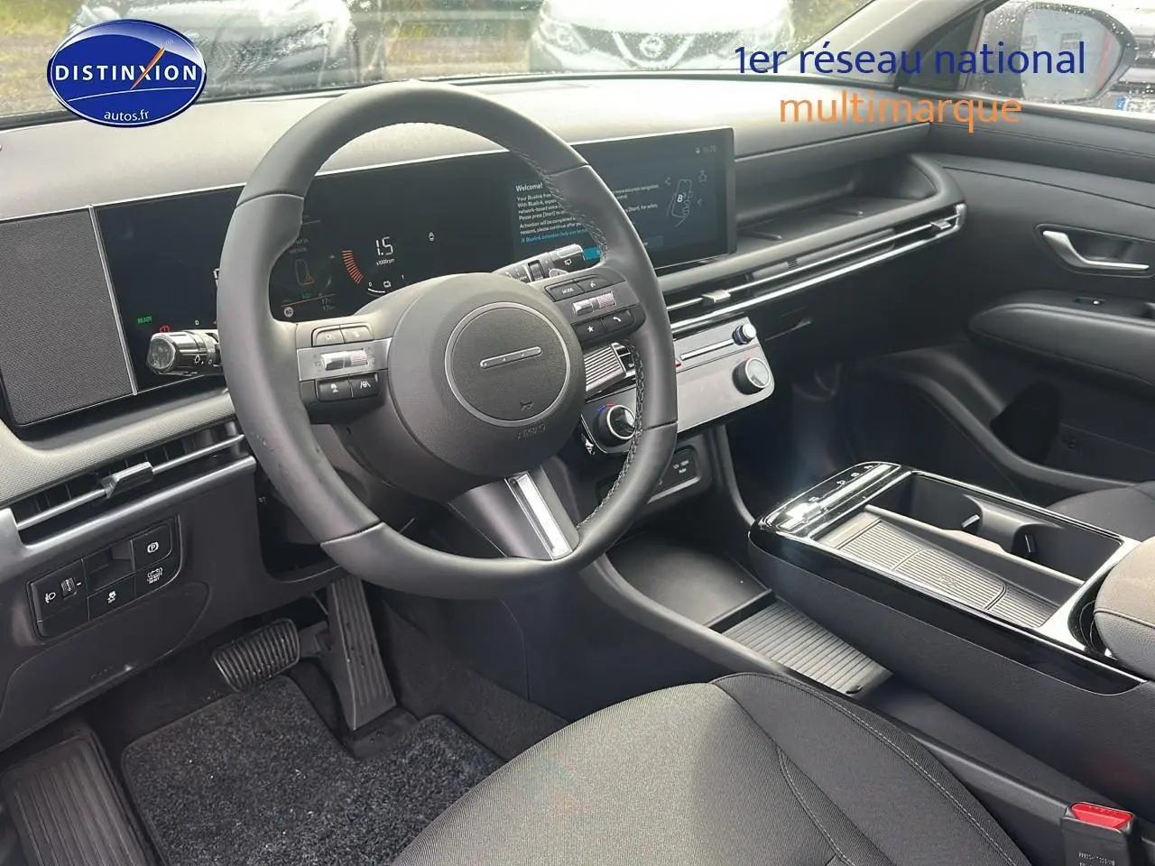 Intérieur moderne du Hyundai Tucson 2025, vue côté conducteur sur le volant cuir et la console centrale noire.