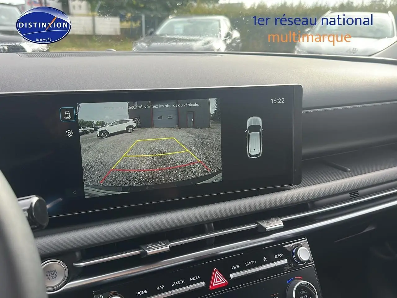 Écran tactile intérieur montrant la caméra de recul d'un Hyundai Tucson vert cyprès en stationnement arrière.