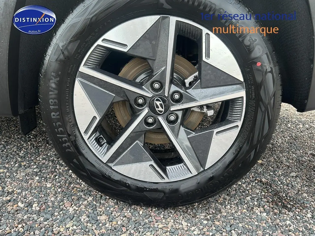 Gros plan sur la jante alliage 18 pouces du Hyundai Tucson vert cyprès, avec logo Hyundai au centre.