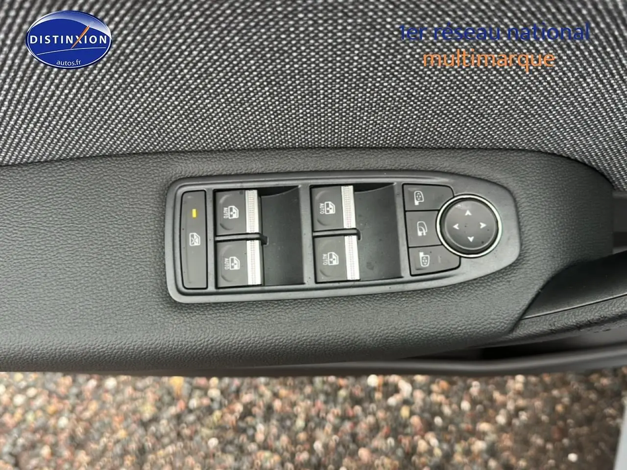 Gros plan sur les commandes des vitres et rétroviseurs côté conducteur du Renault Captur gris rafale 2026.