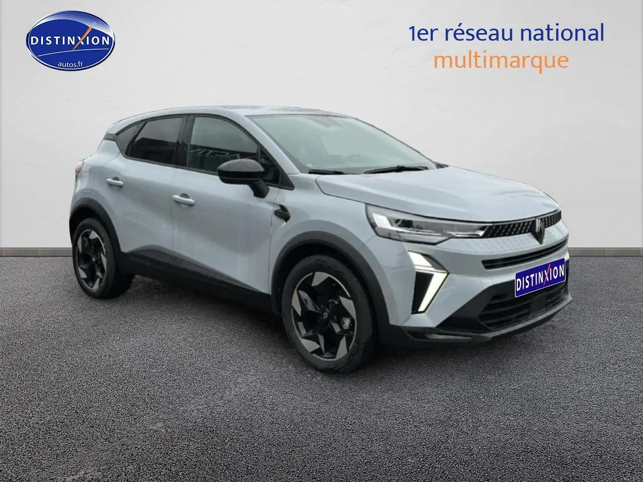 Renault Captur gris rafale en 3/4 avant droit, avec jantes alu noires et feux LED allumés.