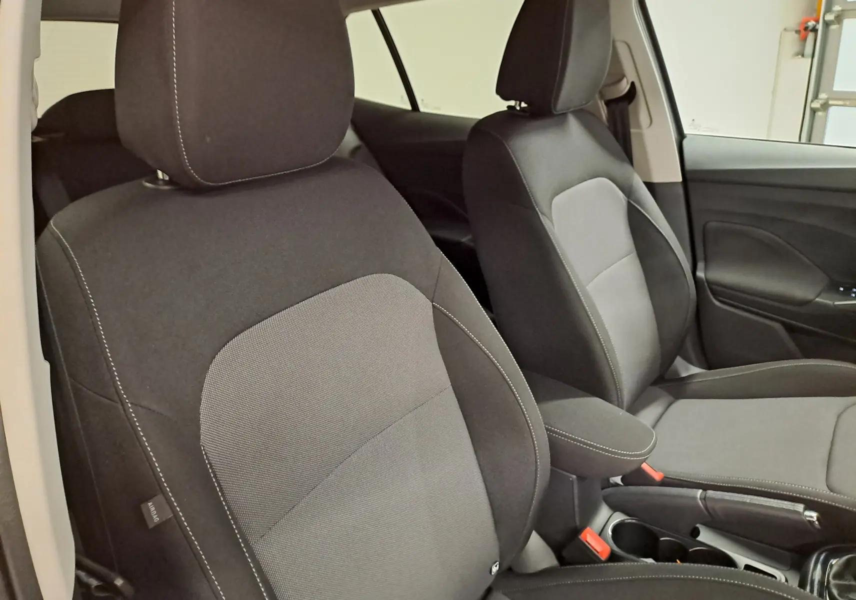 Vue intérieure sur les sièges avant en tissu noir et gris de la Skoda Fabia 1.0 TSI 116 DSG7 Gris Graphite 2025.