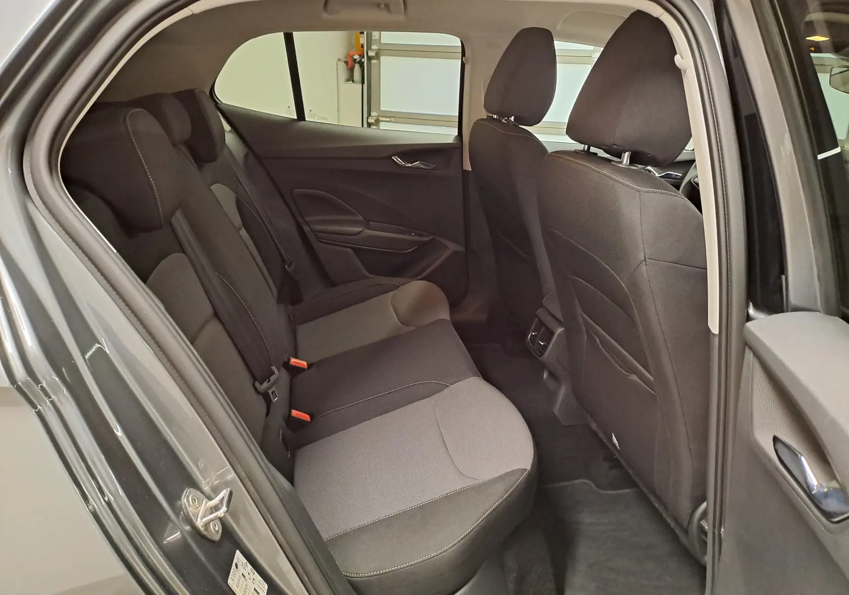Vue intérieure côté gauche de la banquette arrière du Skoda Fabia gris graphite 2025 avec sièges tissu noir et gris.