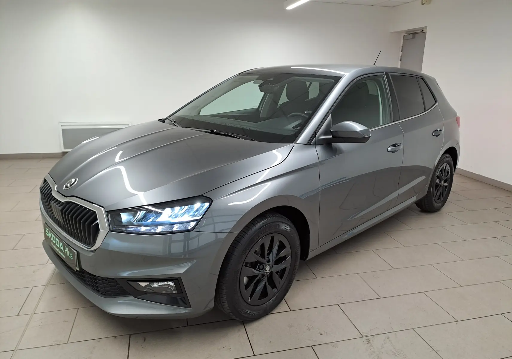 Vue 3/4 avant droite d'une Skoda Fabia gris graphite avec jantes alliage noires et vitres surteintées.