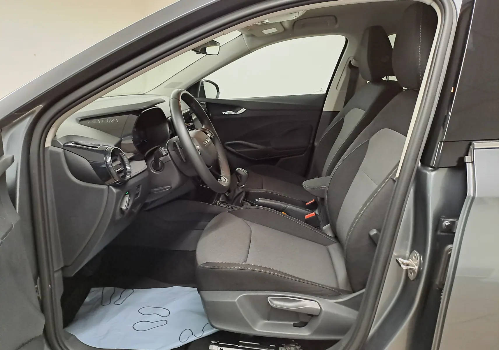 Intérieur côté conducteur de la Skoda Fabia 2025 gris graphite, montrant les sièges tissu et le tableau de bord moderne.