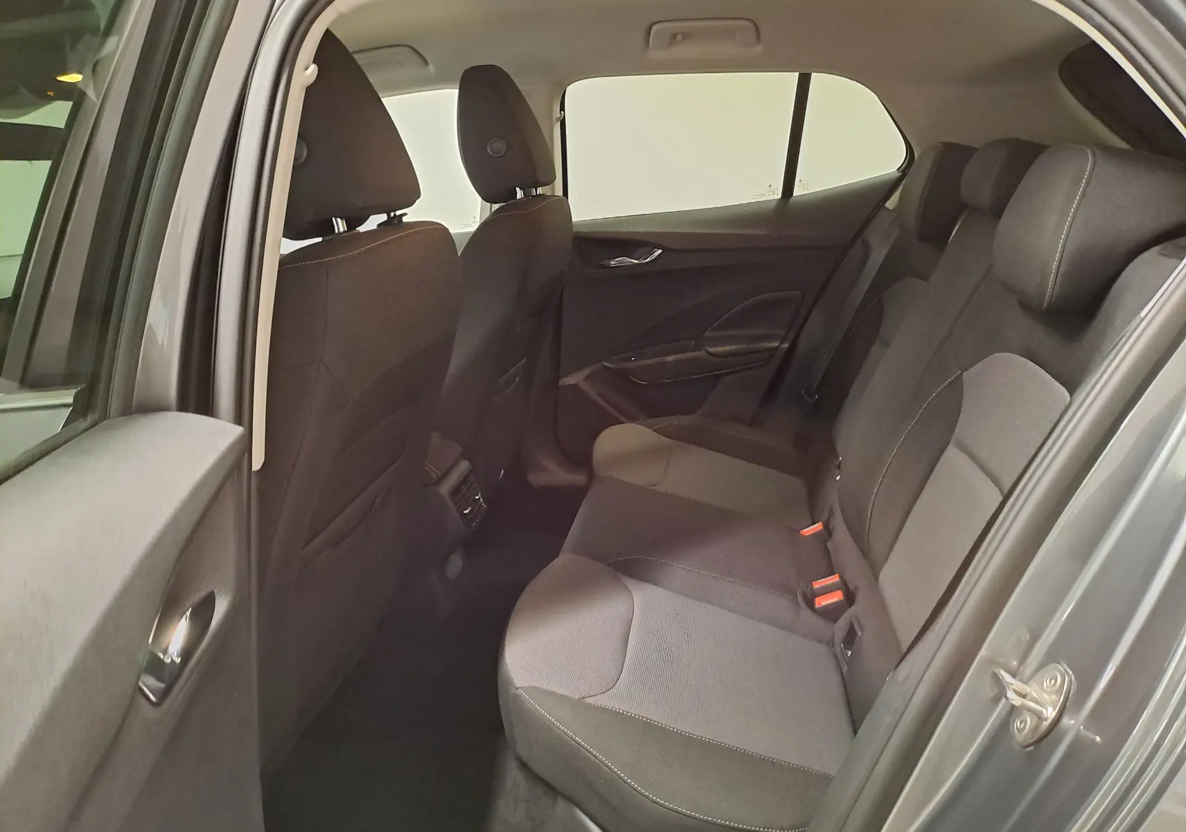 Vue intérieure arrière côté gauche de la Skoda Fabia gris graphite, montrant les sièges tissu et les finitions de porte.