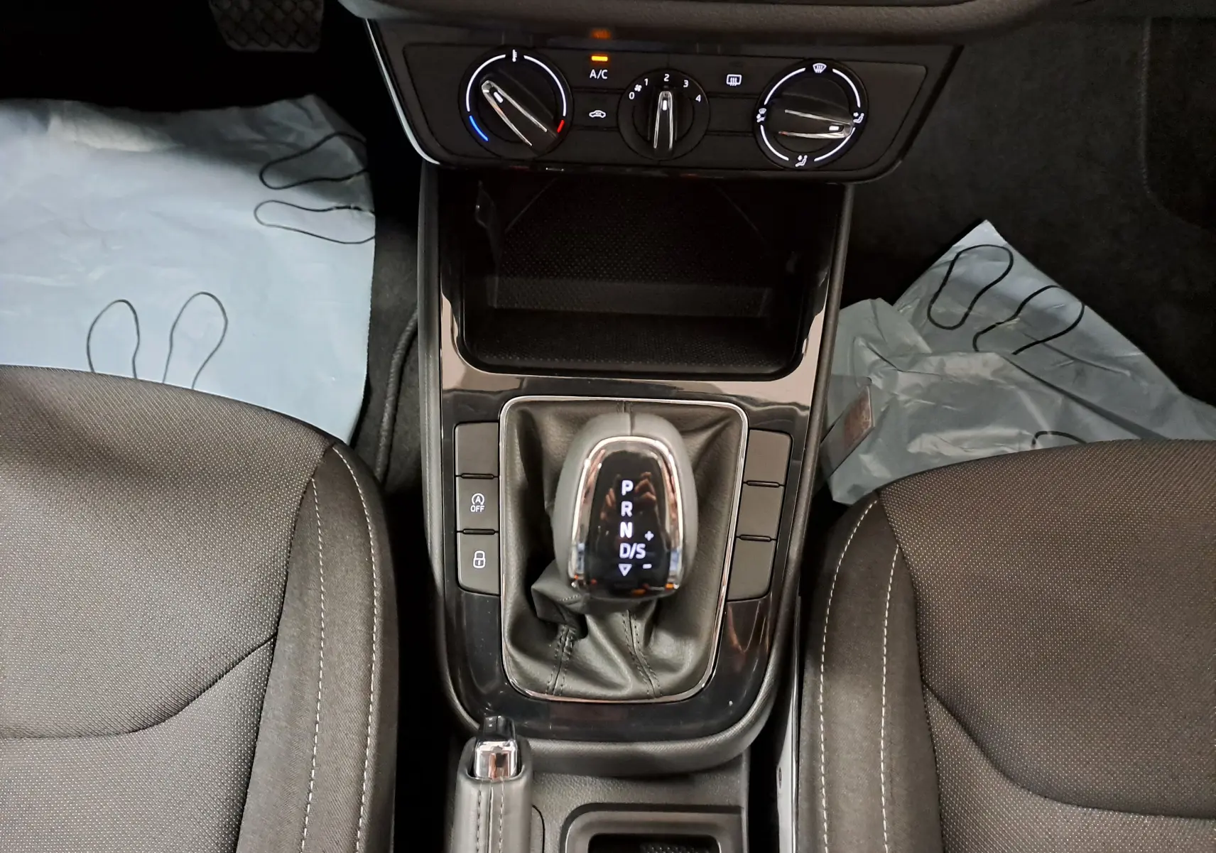 Vue rapprochée de la console centrale de la Skoda Fabia 2025 avec levier de vitesse automatique et sièges gris foncé.