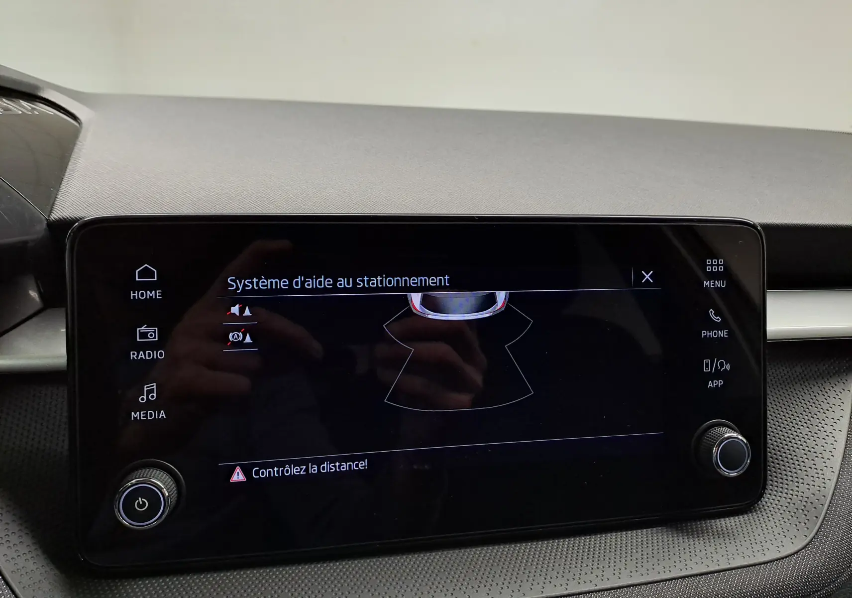 Écran tactile intérieur du Skoda Fabia 2025 montrant le système d'aide au stationnement avec commandes autour.