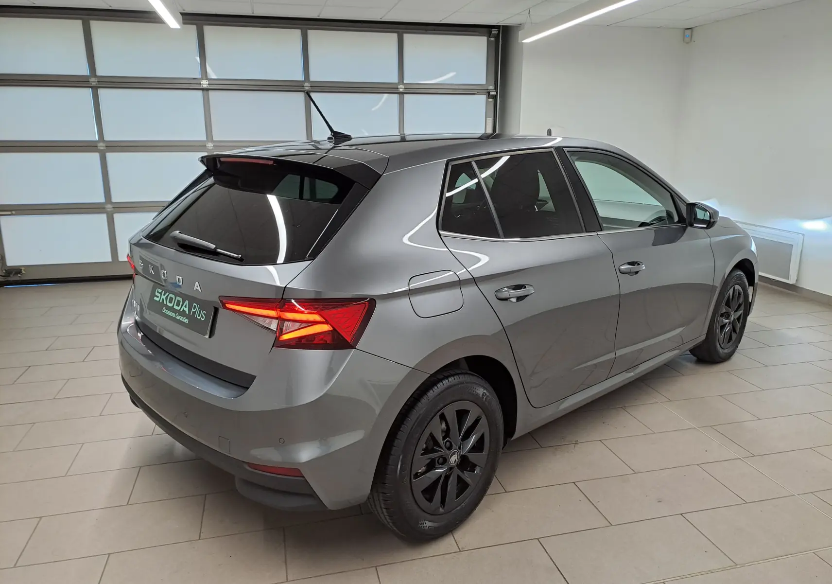 Vue 3/4 arrière droite d'une Skoda Fabia 2025 gris graphite avec jantes alliage noires et vitres surteintées.