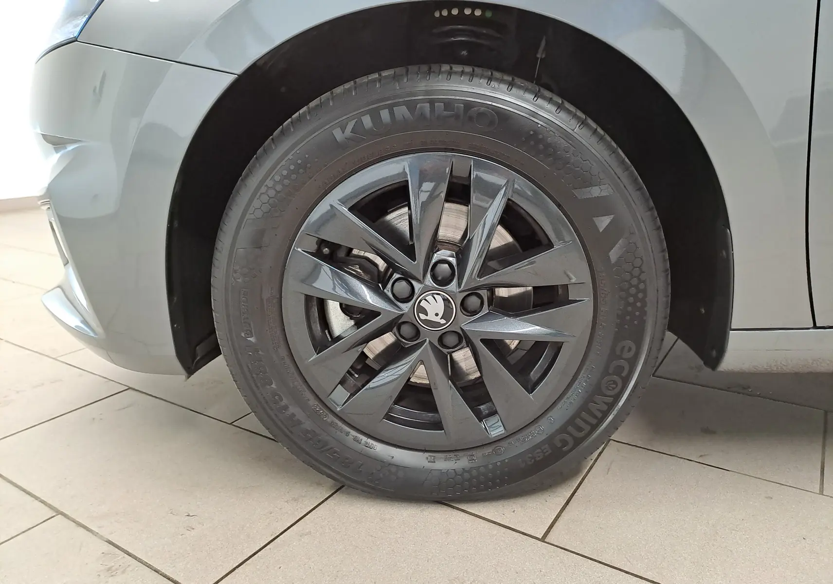 Gros plan sur la roue avant gauche d’une Skoda Fabia 2025 gris graphite avec jante alliage noire 15 pouces.