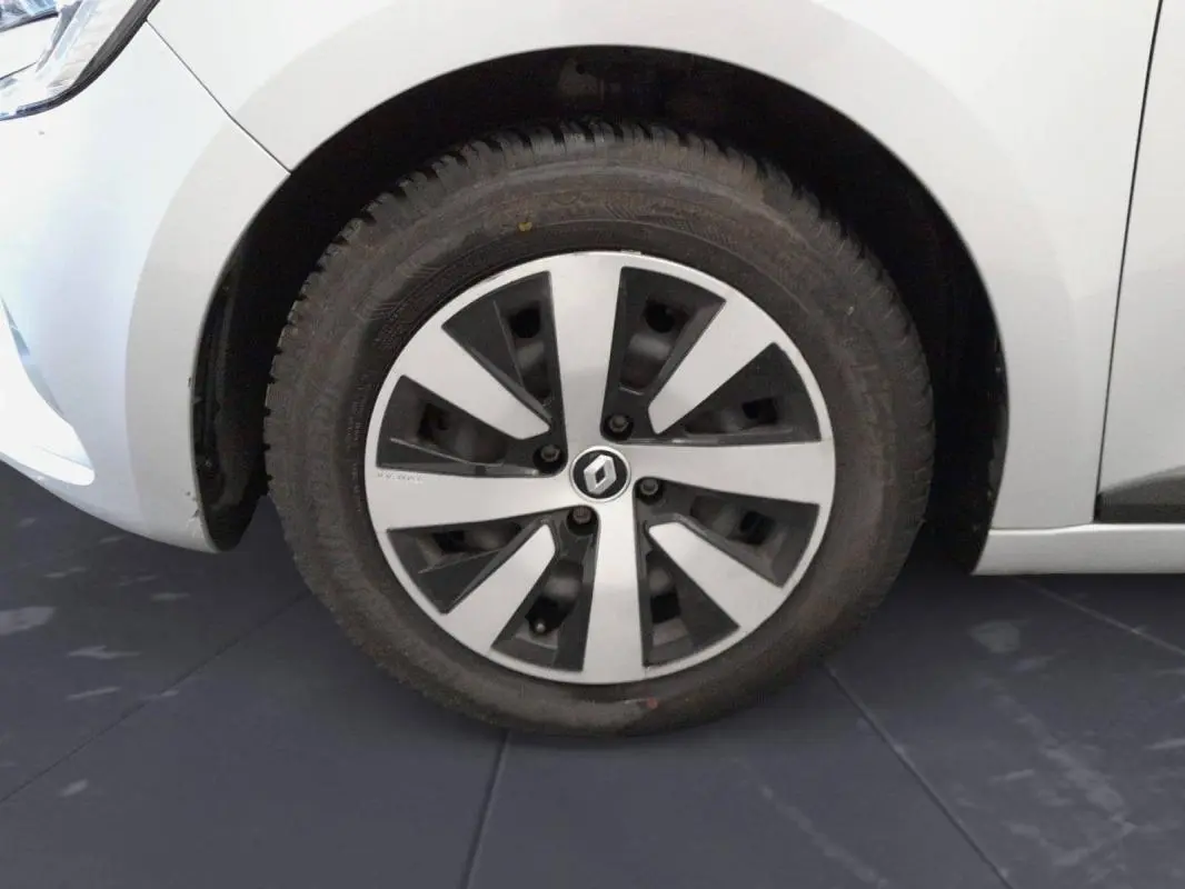 Gros plan sur la roue avant gauche d’une Renault Clio gris clair 2022 avec jante alliage au design moderne.