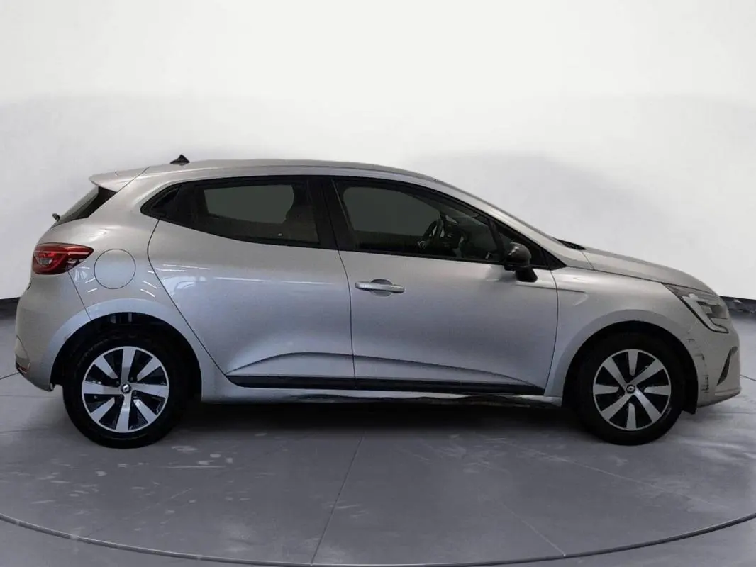 Profil côté gauche d'une Renault Clio gris clair 2022, version V TCe 90 Equilibre, sur fond neutre intérieur.