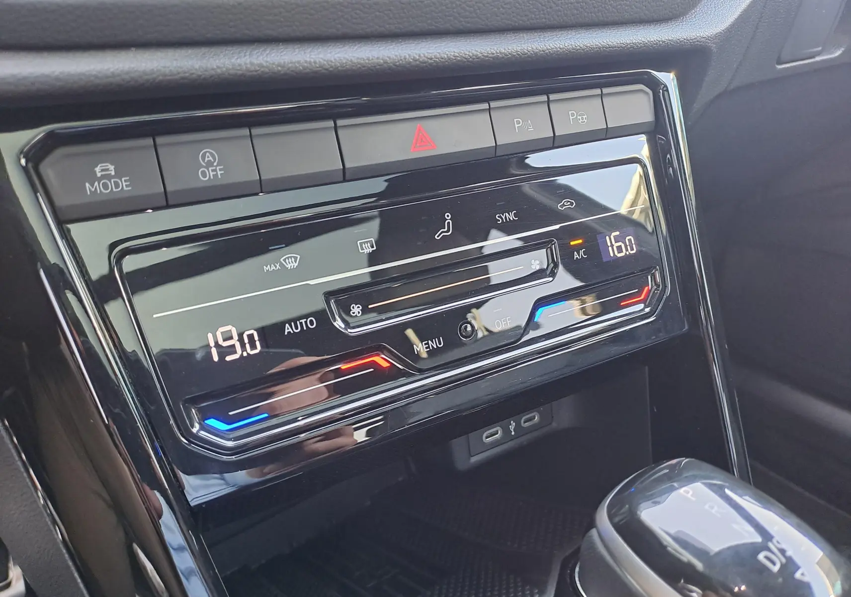 Gros plan sur la console centrale du Volkswagen T-Roc 2025, affichage numérique de la climatisation automatique.