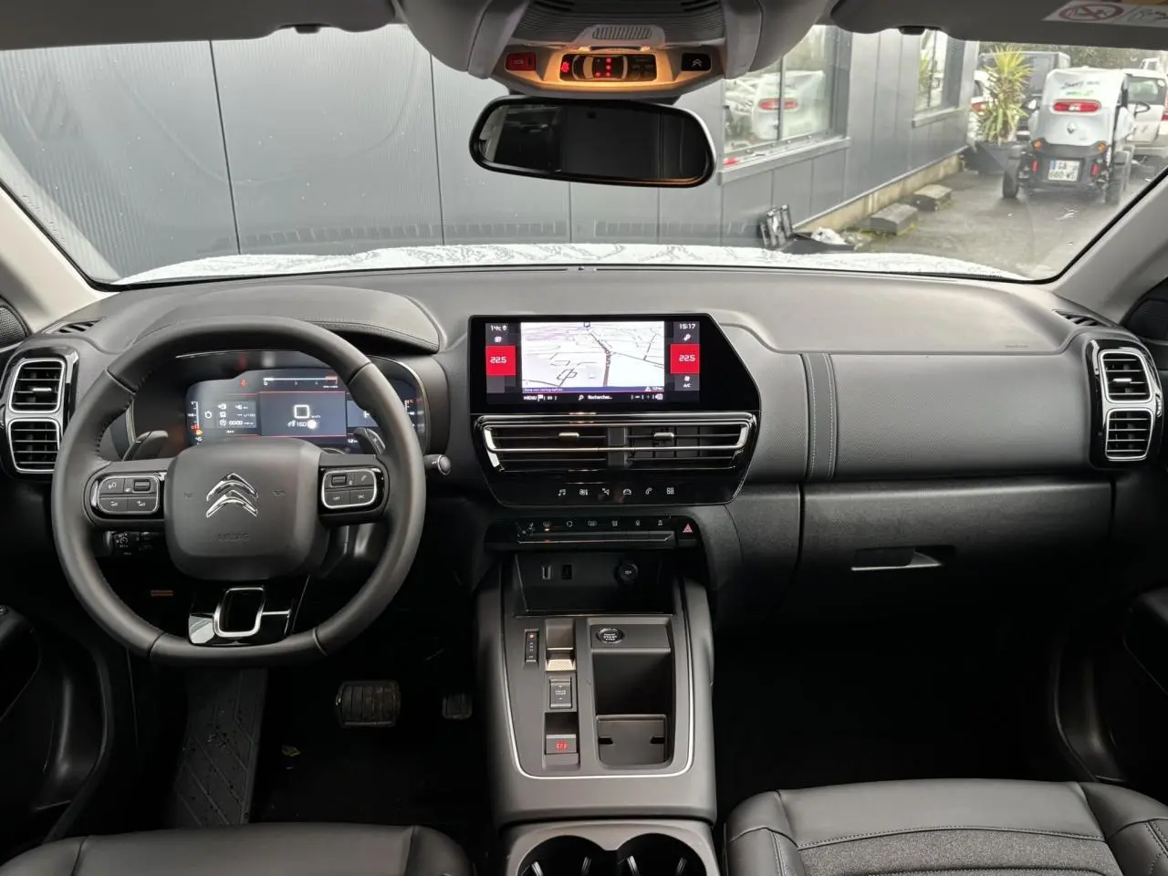 Vue intérieure frontale du tableau de bord noir du Citroën C5 Aircross 2025 avec écran tactile central et volant multifonction.