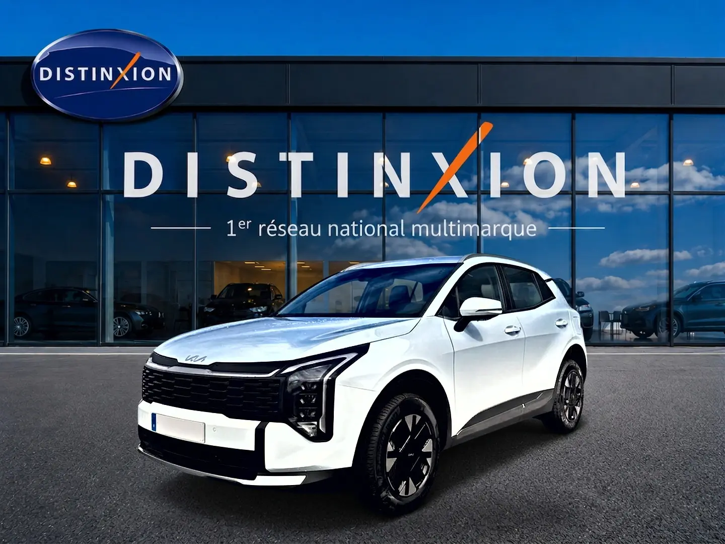 KIA Sportage 1.6 hybride blanc en 3/4 avant droit, avec calandre noire et jantes alu noires devant un showroom Distinxion.