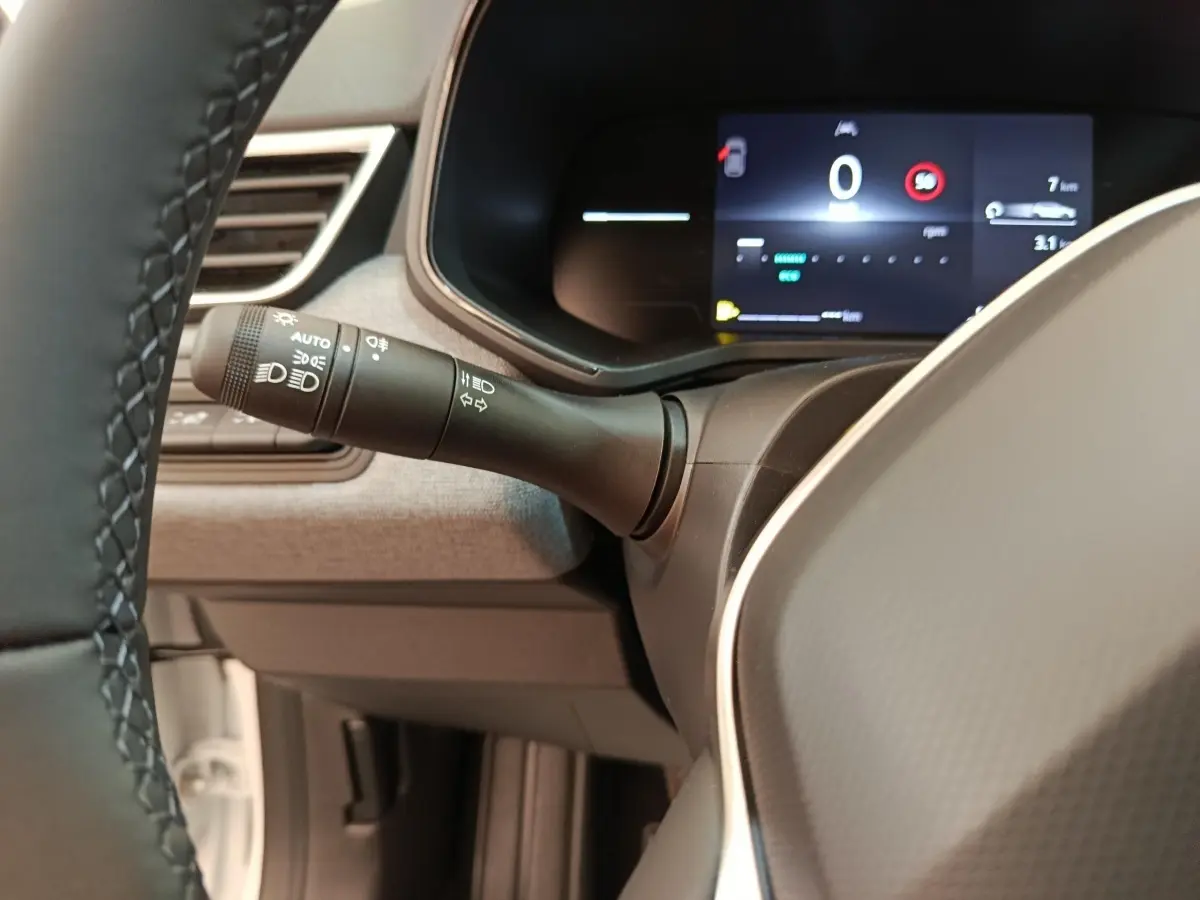 Gros plan intérieur sur le combiné d'instruments numérique et la commande des phares de la Renault Clio 2024.