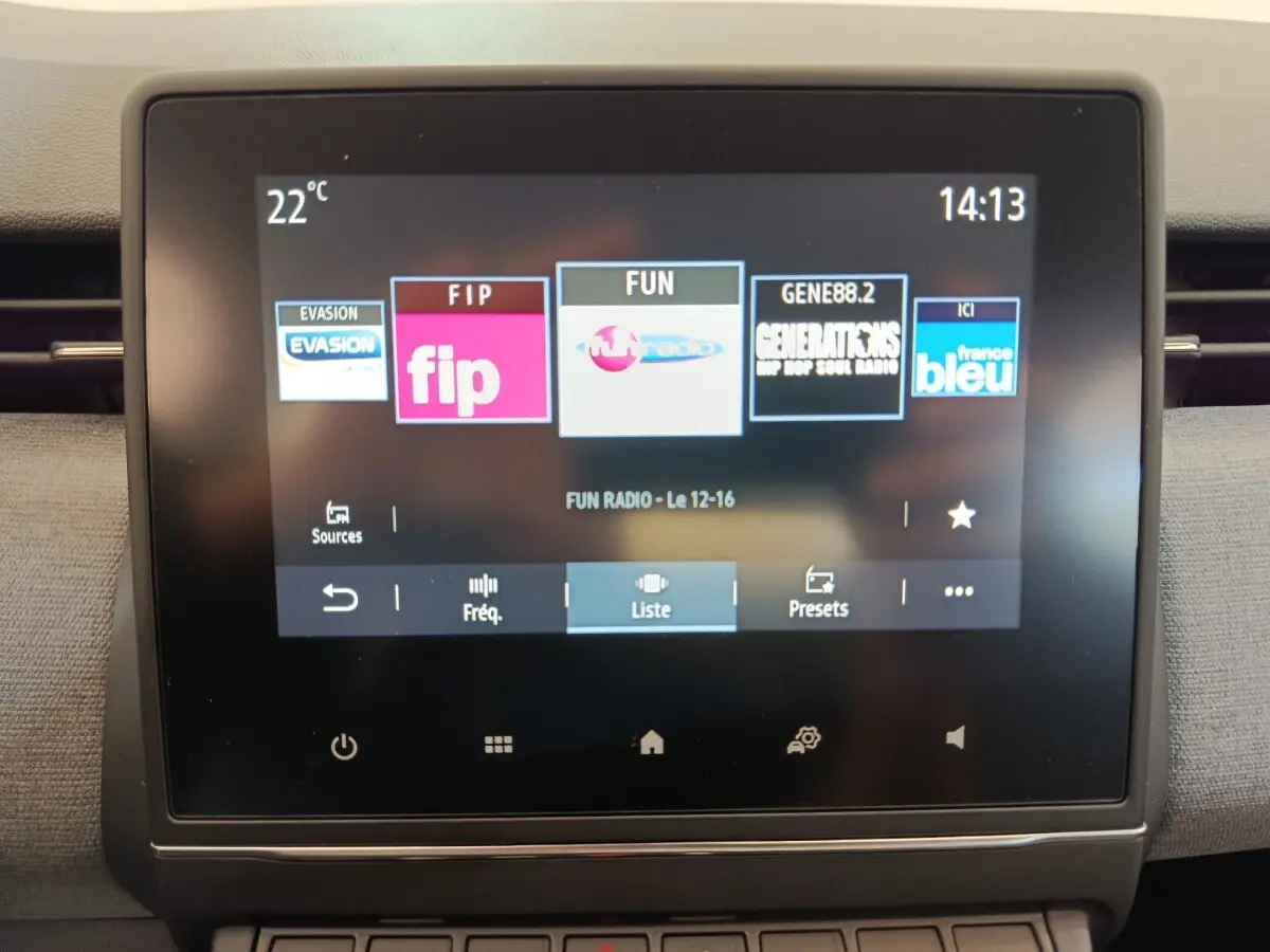 Écran tactile central de la Renault Clio 2024 affichant les stations radio, vue frontale rapprochée.
