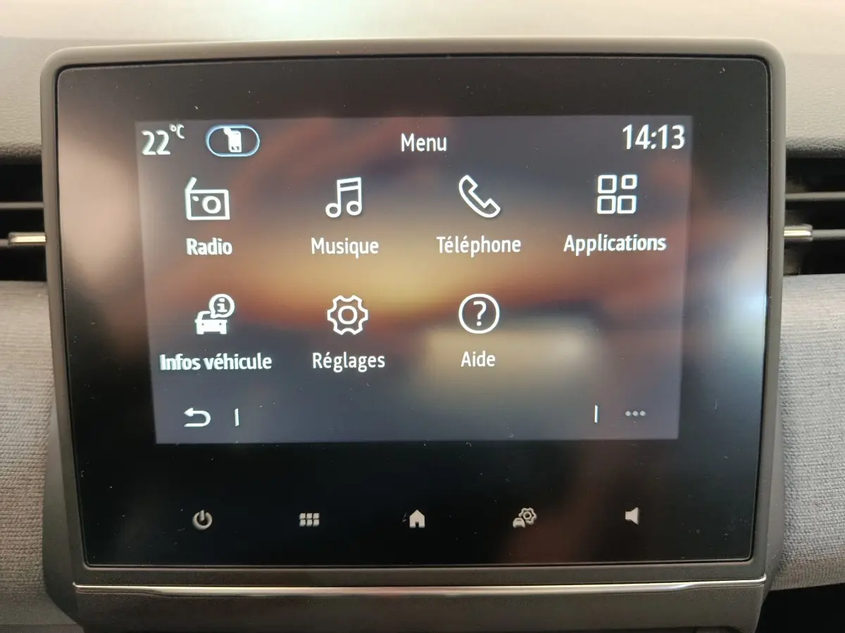 Écran tactile central de la Renault Clio 2024 affichant le menu principal avec icônes blanches sur fond sombre.