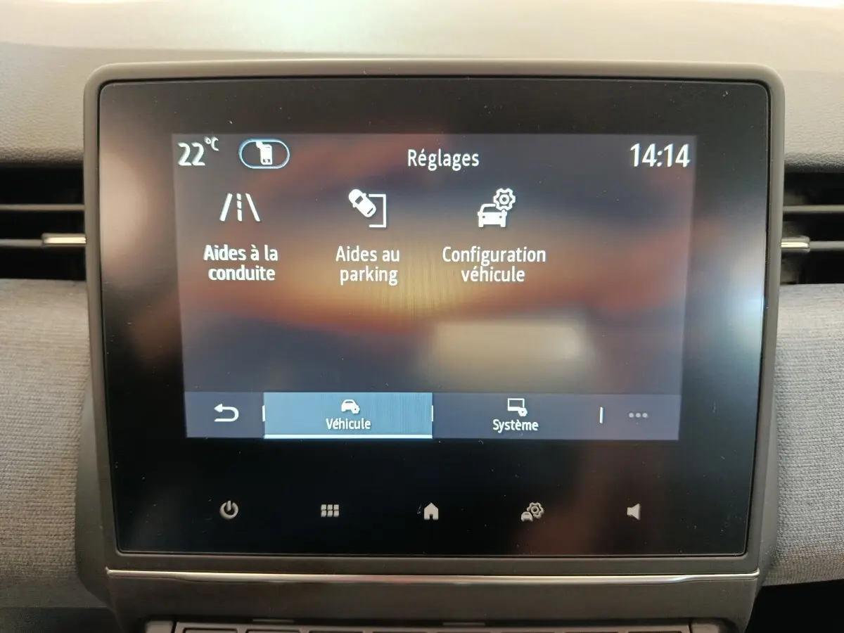 Écran tactile central de la Renault Clio 2024 affichant les réglages d’aides à la conduite et au parking.