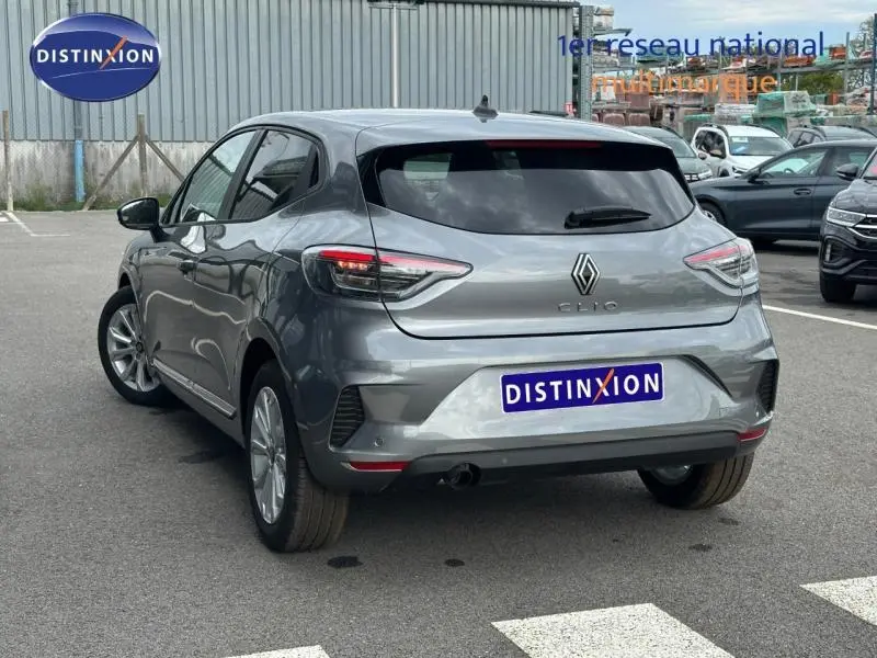 Vue 3/4 arrière droite d'une Renault Clio gris métallisé 2025 avec logo et feux arrière LED distinctifs.