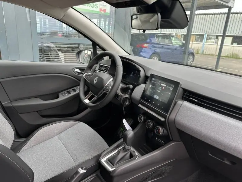 Vue intérieure côté conducteur de la Renault Clio 2025 gris, avec tableau de bord numérique et écran tactile central.