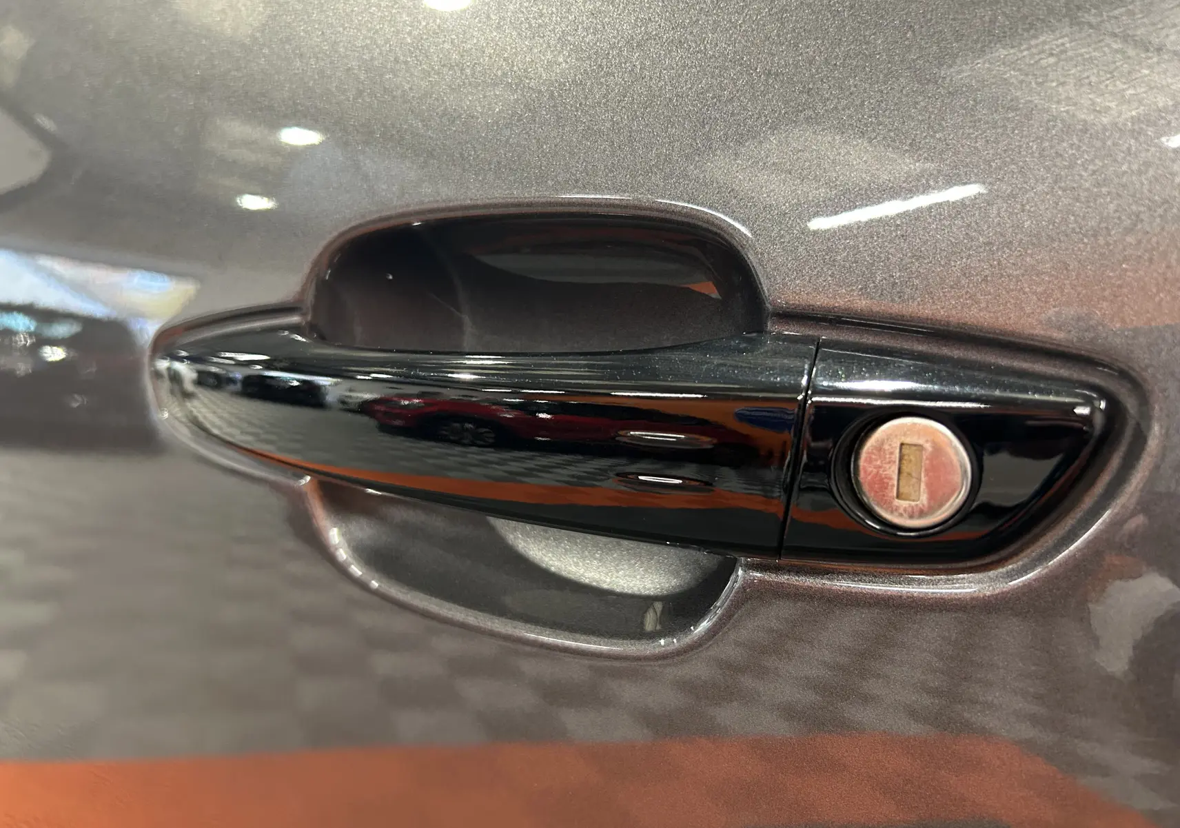 Gros plan sur la poignée de porte noire avec serrure sur la portière gris platinium d'une Citroën C5 Aircross 2025.