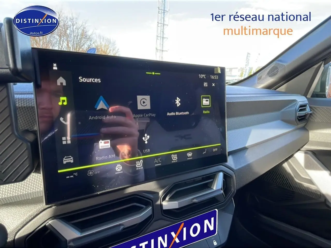 Vue intérieure du tableau de bord du Dacia Duster 2026 noir, avec écran tactile central et aérateurs angulaires.