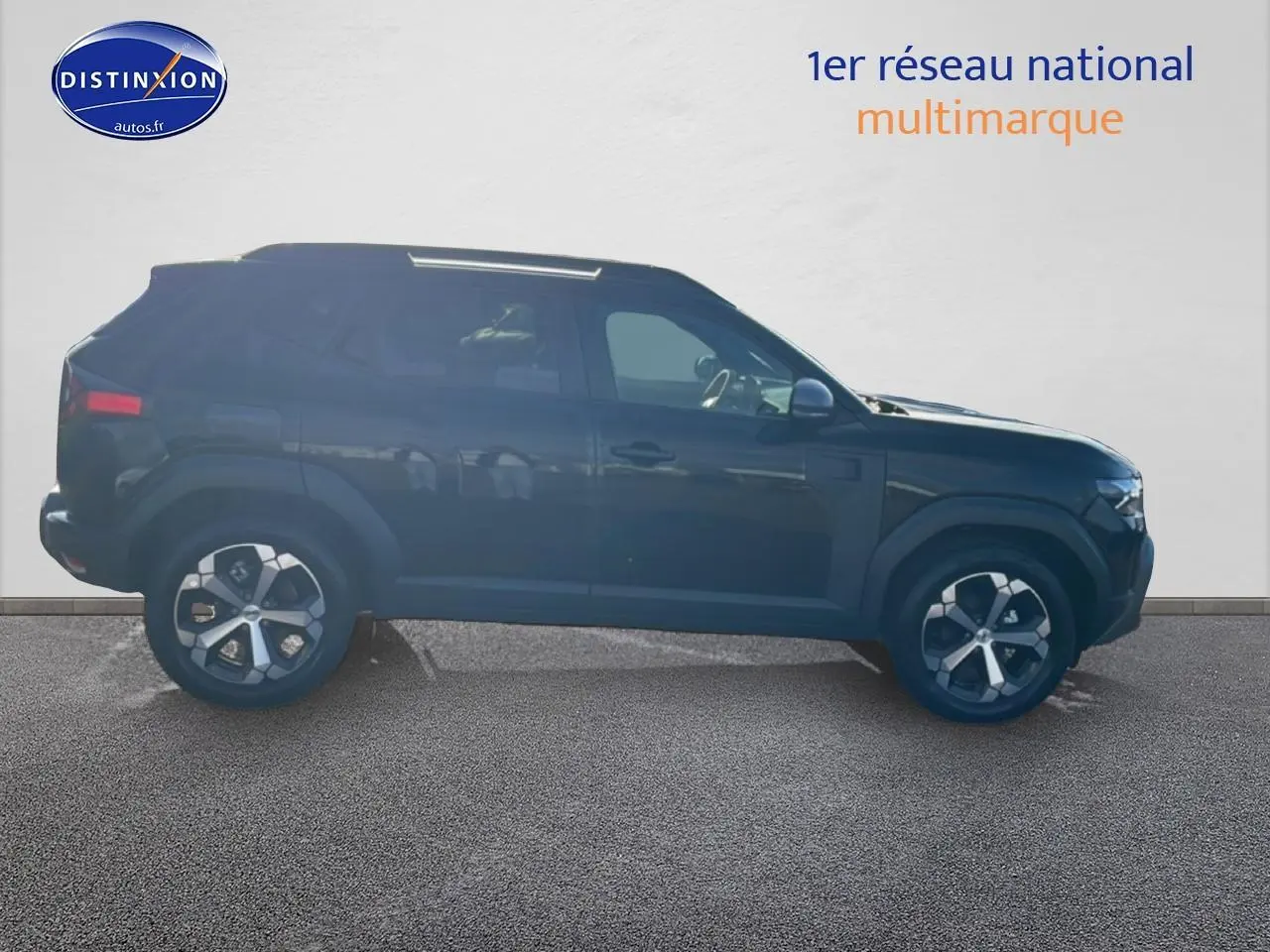 Profil côté gauche du Dacia Duster 1.2 mild hybrid noir 2026 avec jantes alu et barres de toit visibles.