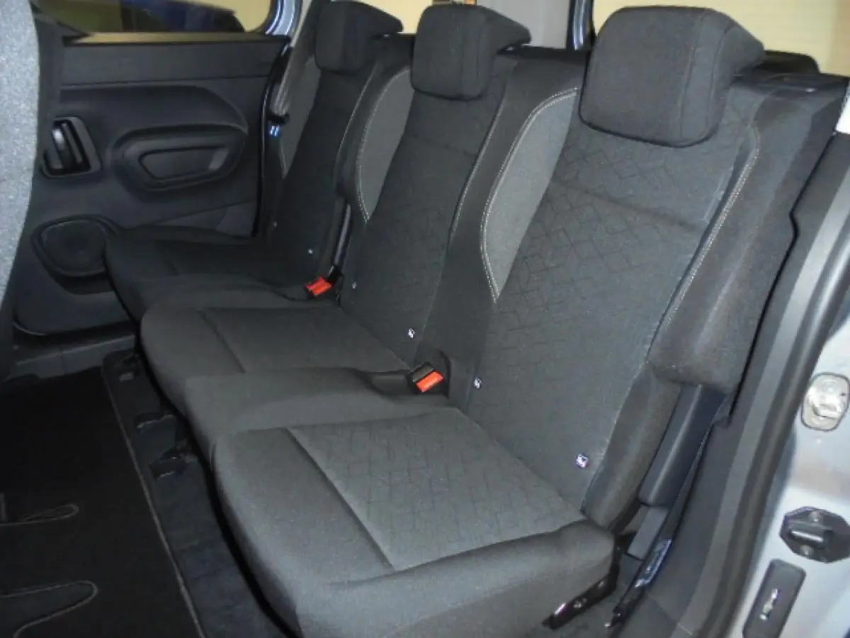 Vue intérieure des sièges arrière en tissu gris foncé du Peugeot Rifter 2020, porte ouverte côté droit visible en gris Artense.