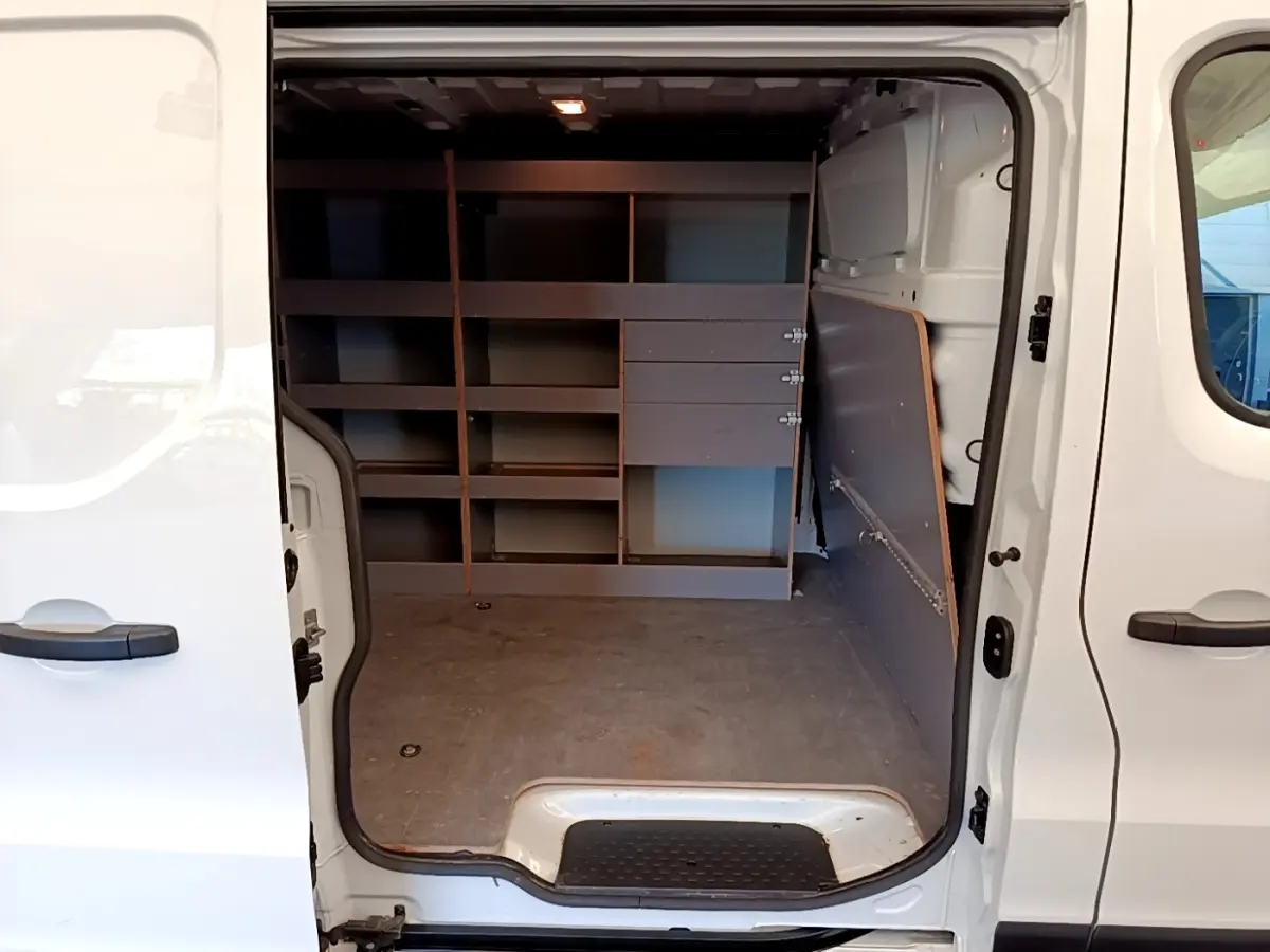 Vue intérieure côté droit du Renault Trafic Fourgon blanc 2021, montrant l'espace de chargement avec étagères intégrées.