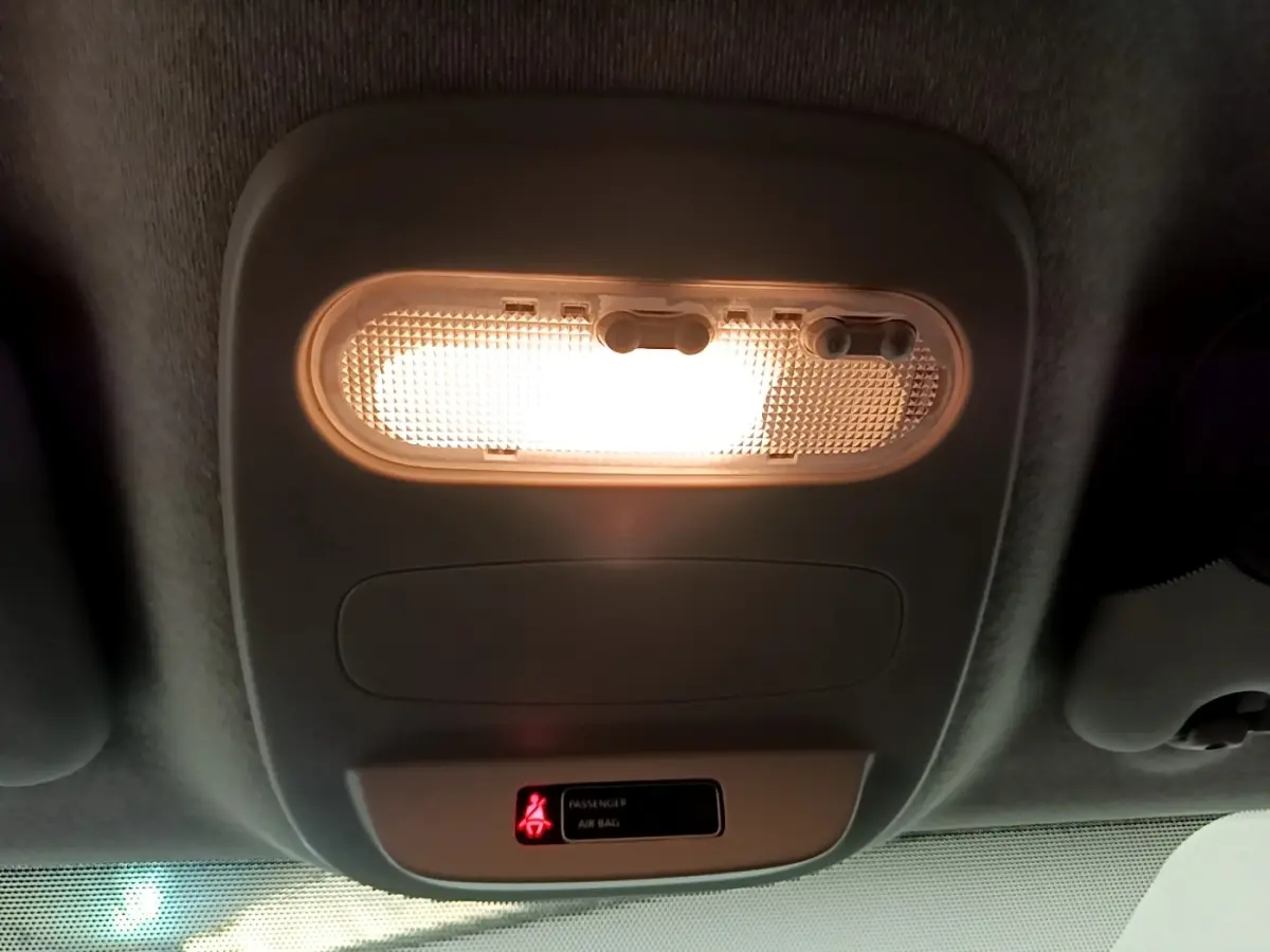 Plafonnier intérieur allumé du Renault Trafic Fourgon blanc, vue en contre-plongée sur la console de toit.