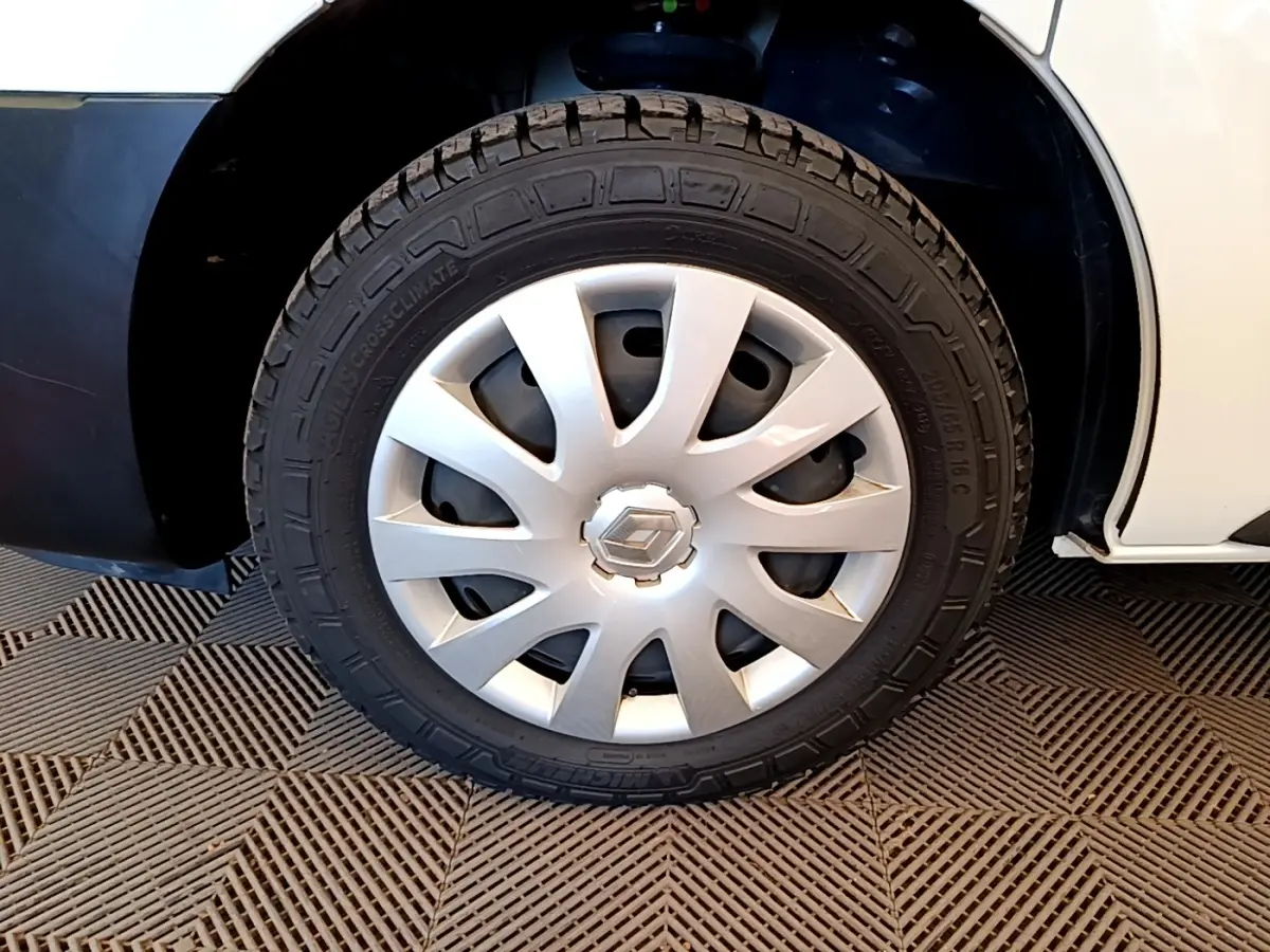 Gros plan sur la roue avant droite du Renault Trafic Fourgon blanc, avec enjoliveur argenté et logo Renault central.