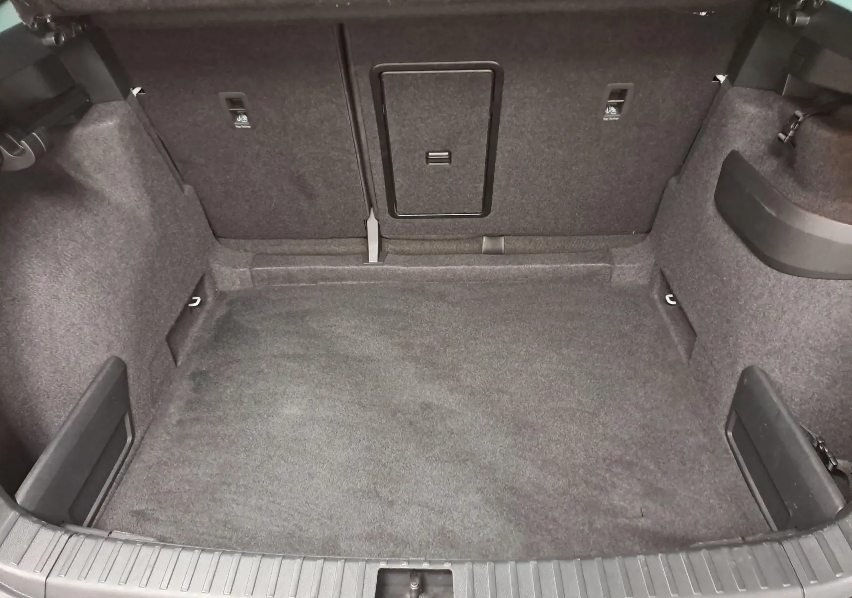 Coffre spacieux et vide du Skoda Karoq 2025, vue intérieure arrière avec revêtement tissu gris foncé.