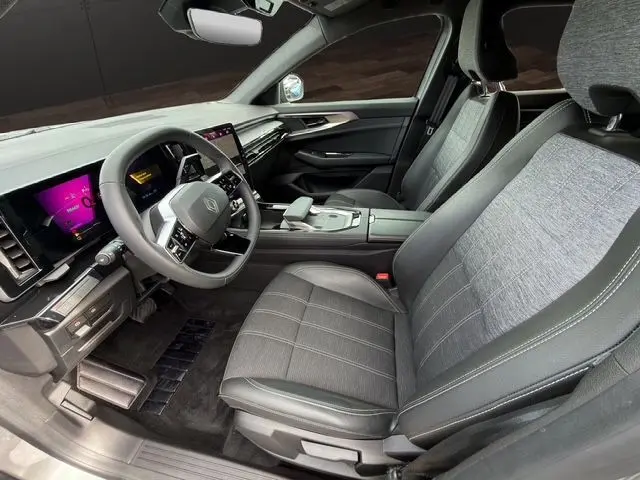 Vue intérieure côté conducteur du Renault Austral E-Tech gris Casiopee, avec tableau de bord numérique et sellerie mixte gris.