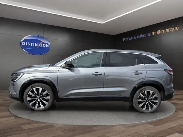 Vue de profil côté gauche du Renault Austral gris Casiopee, SUV hybride avec jantes alliage 19 pouces diamantées noir.