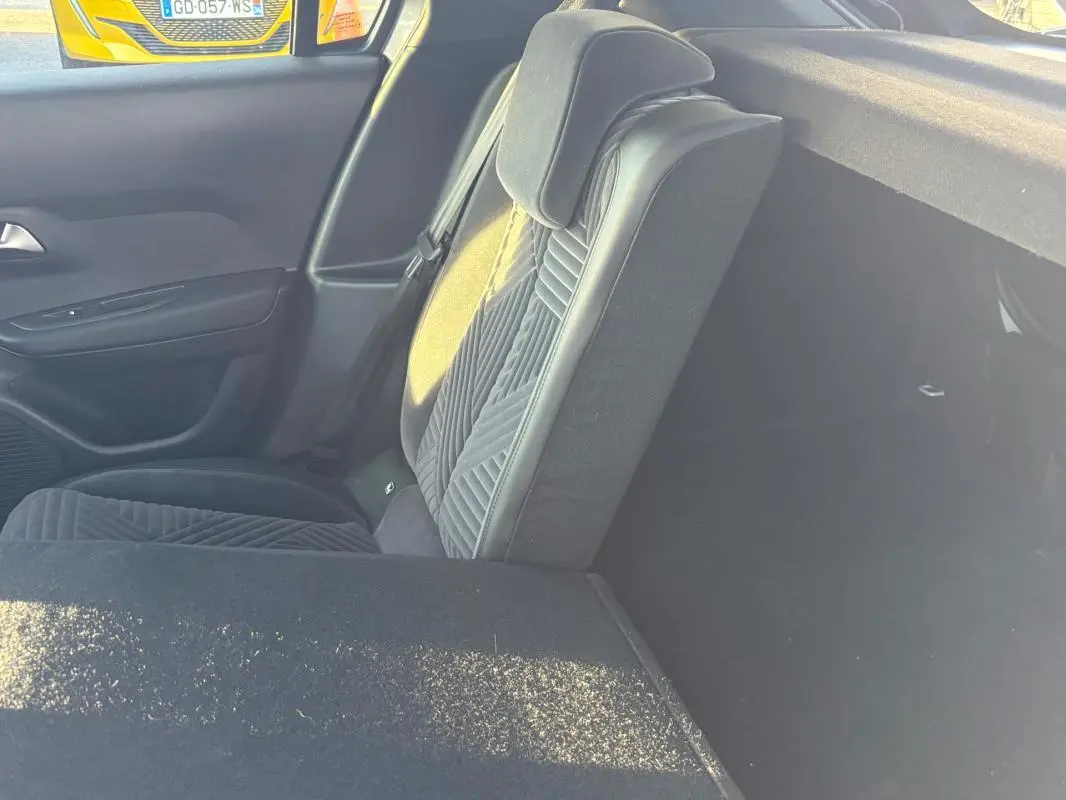 Vue intérieure côté droit sur le siège arrière gris avec détails en tissu et cuir, et partie du coffre visible.