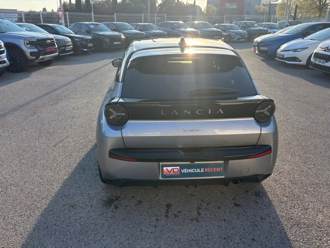 Vue arrière d'une Lancia Ypsilon gris métallisé 2025, avec feux ronds et logo LANCIA bien visible.