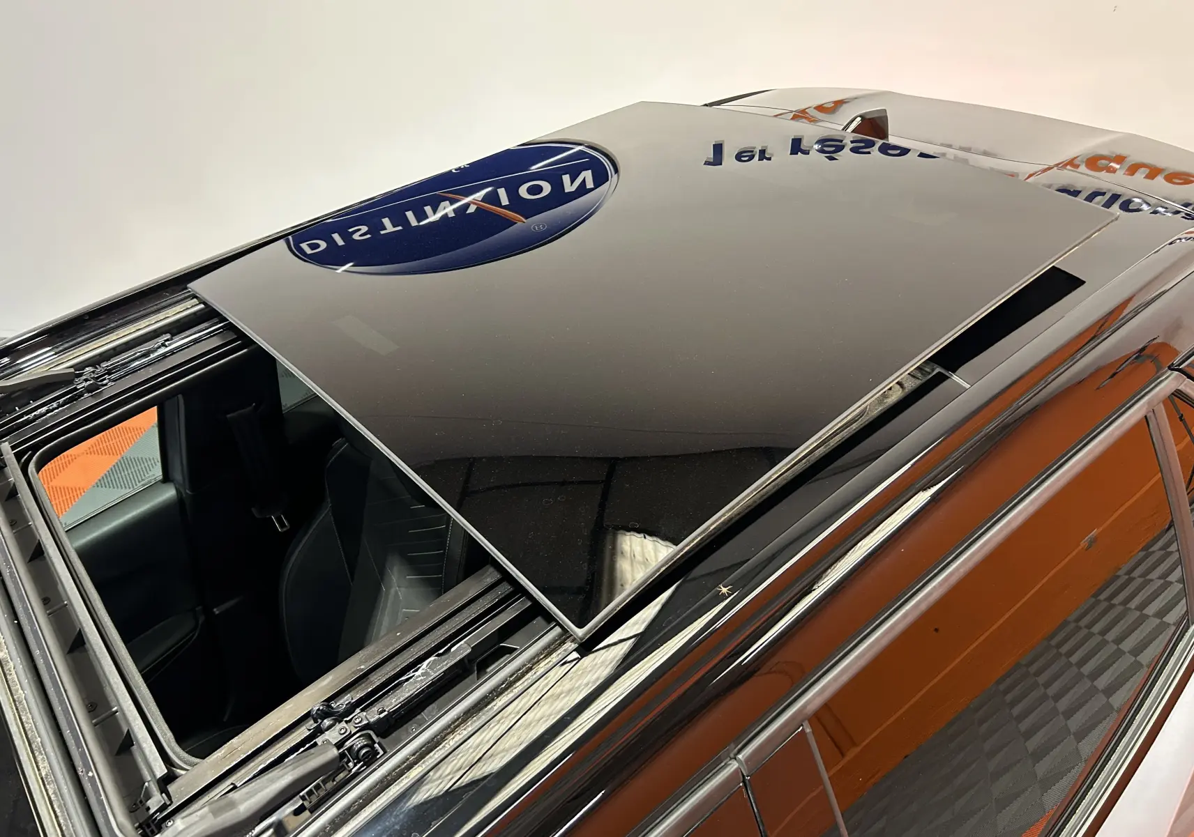 Toit ouvrant panoramique en verre noir sur Peugeot 2008 gris Artense, vue en plongée depuis l'arrière côté gauche.