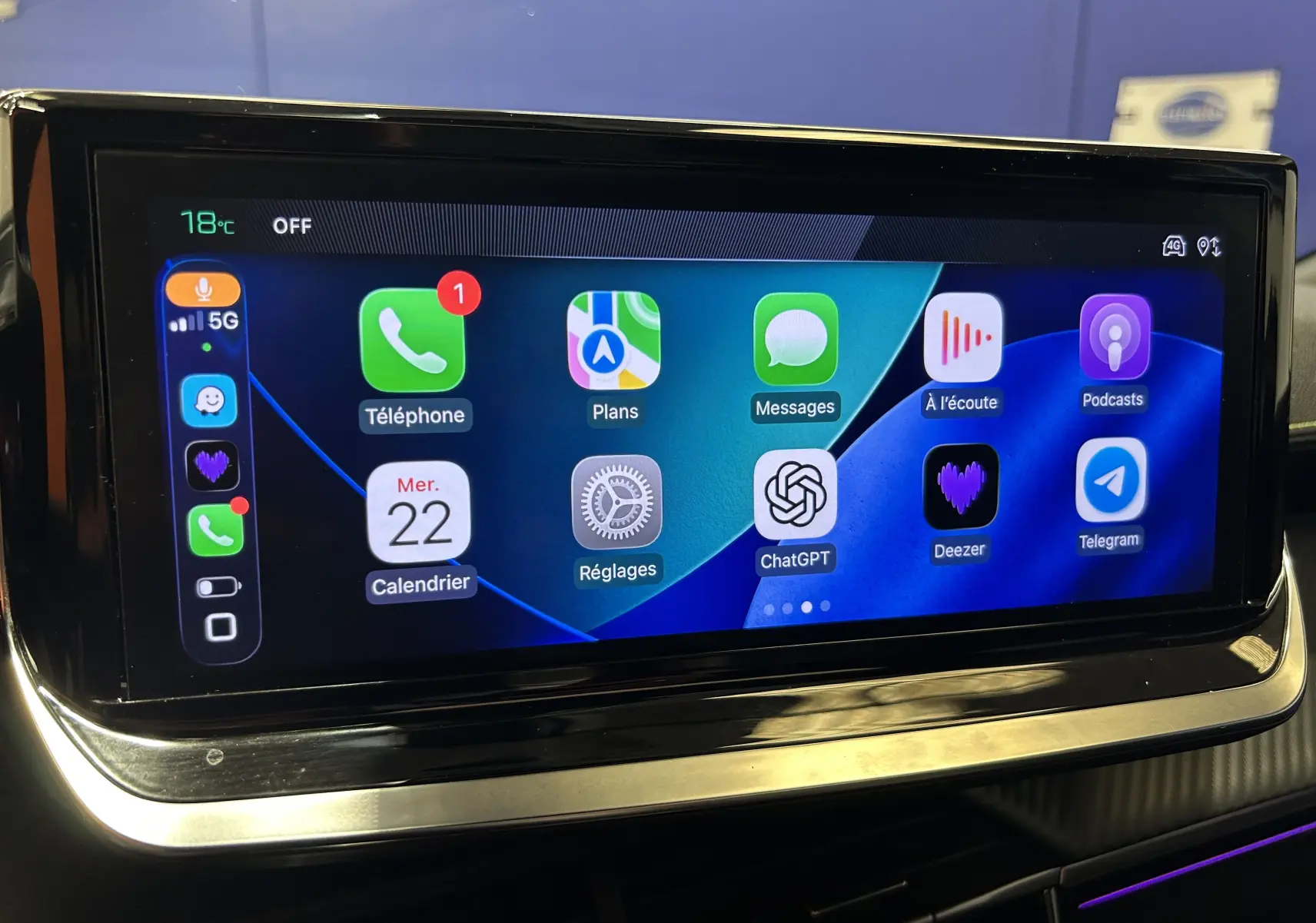 Écran tactile central du Peugeot 2008 2024 affichant des applications connectées avec interface moderne et fond bleu.