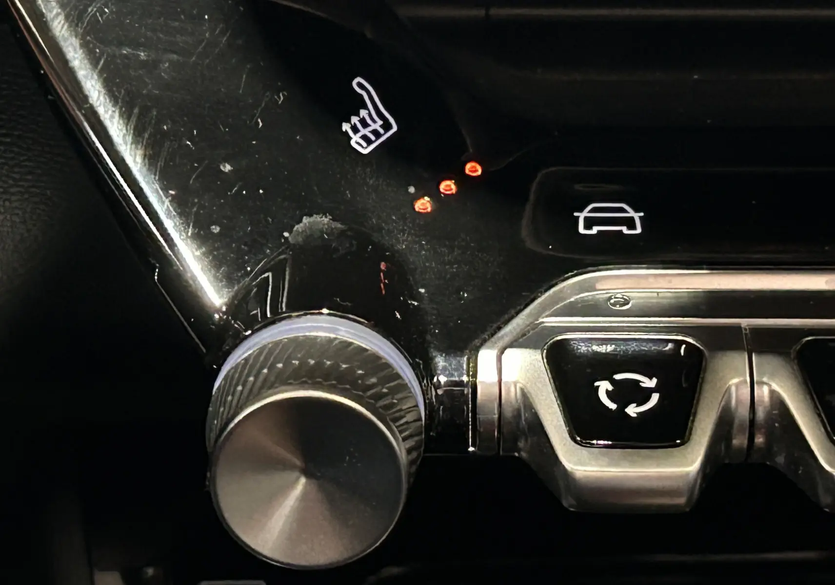 Gros plan sur la molette de réglage du siège chauffant avec témoins lumineux rouges dans l’habitacle noir du Peugeot 2008 Gris Artense.