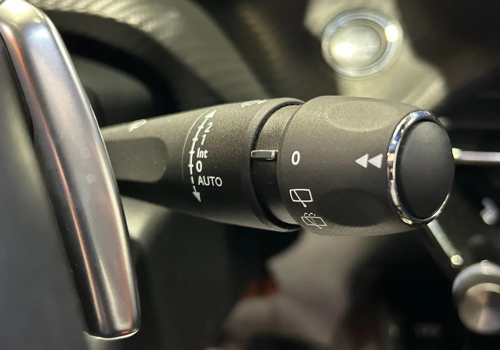 Gros plan sur la commande d’essuie-glace du Peugeot 2008 gris Artense, avec détails des réglages automatiques et manuels.