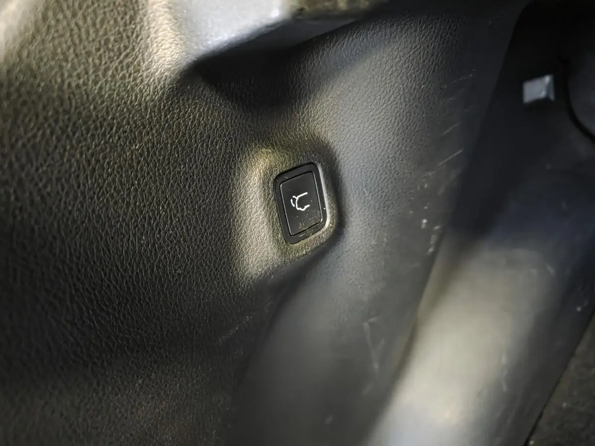 Bouton de hayon électrique intégré dans l'habillage noir intérieur du Jeep Compass Trailhawk hybride rechargeable.