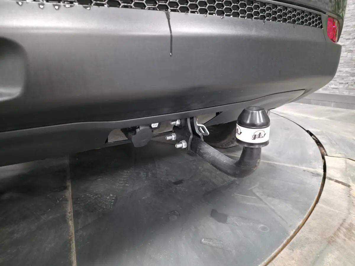 Gros plan sur l'attelage fixe noir sous le pare-chocs arrière gris du Jeep Compass Trailhawk 2020.