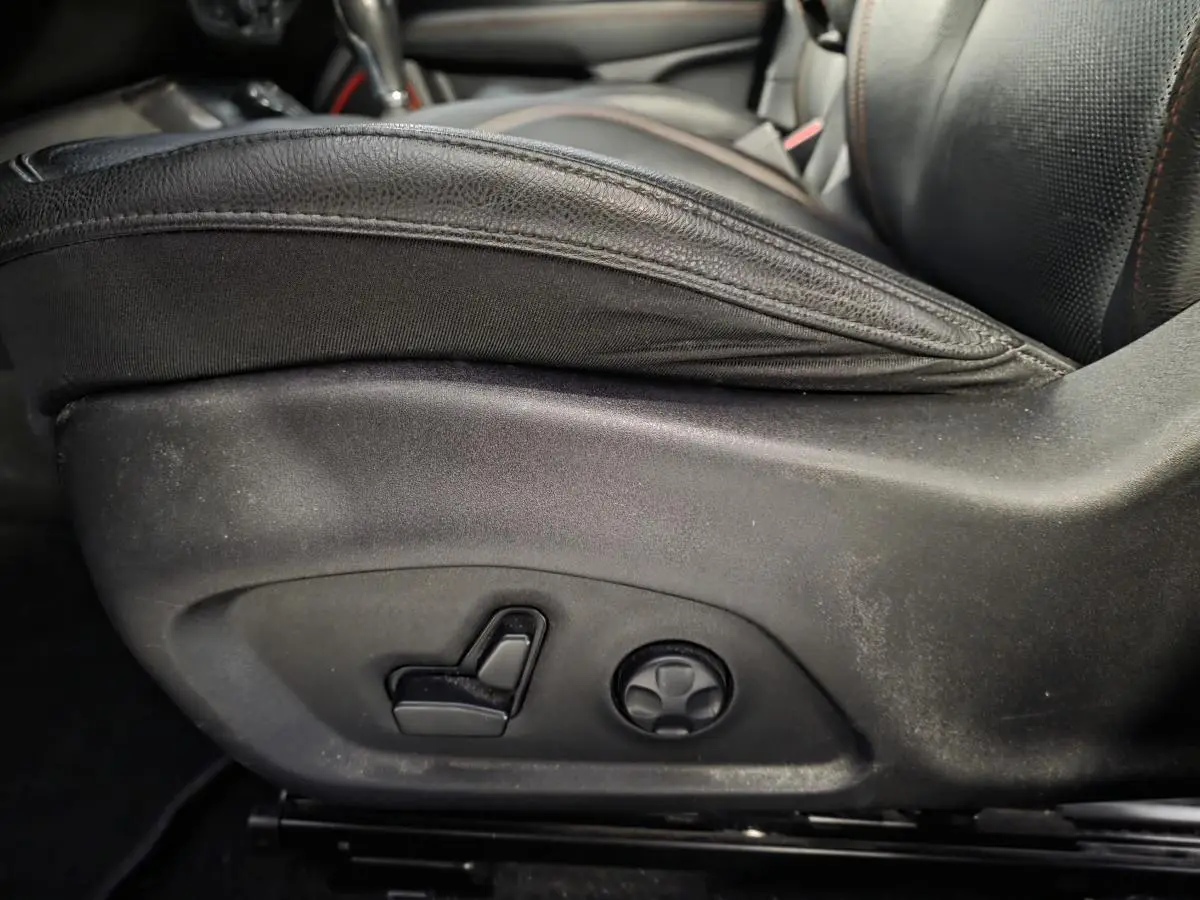 Gros plan sur les commandes électriques du siège conducteur en cuir noir du Jeep Compass Trailhawk gris.