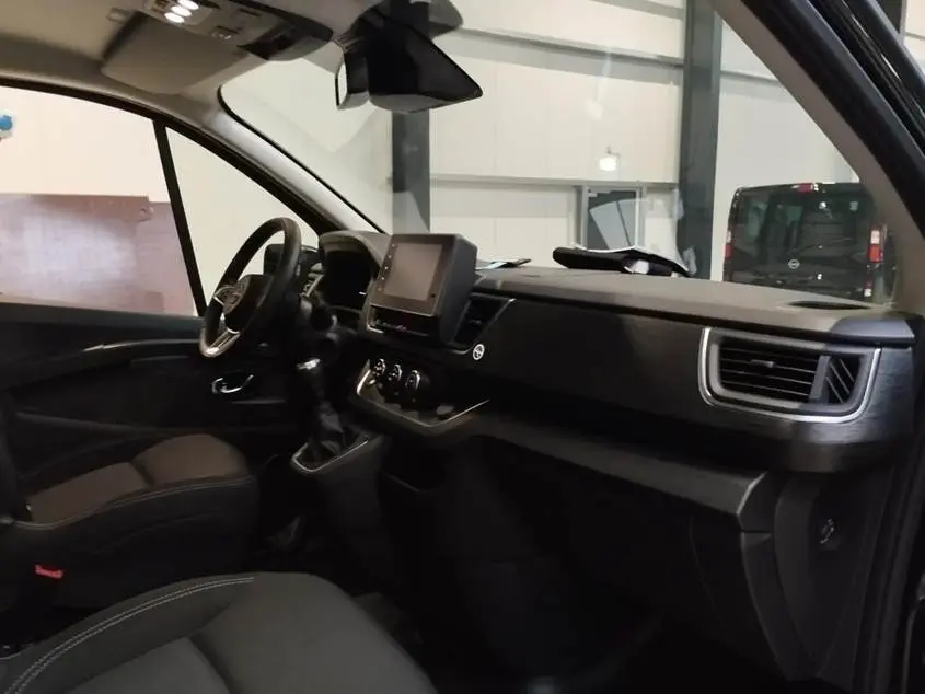 Vue intérieure côté conducteur du Nissan Primastar noir 2025, avec tableau de bord moderne et écran tactile central.