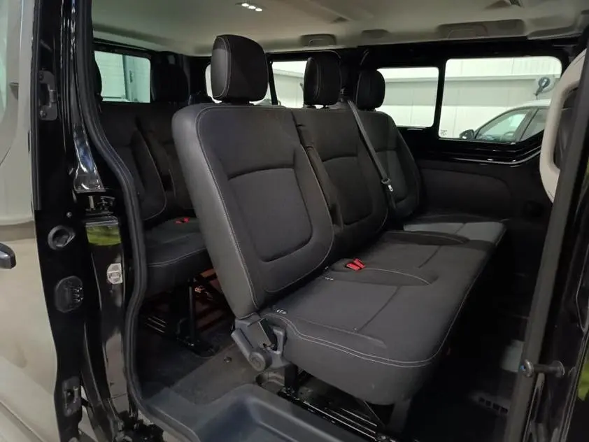 Vue intérieure côté droit du Nissan Primastar noir 2025, montrant la banquette arrière 3 places avec ceintures.